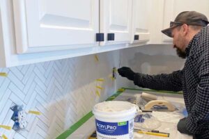 Plumber fixing white sink pipe with adjustable wrench. Pegasus Home Innovations: tile and handyman services in Strongsville, Parma, North Olmsted